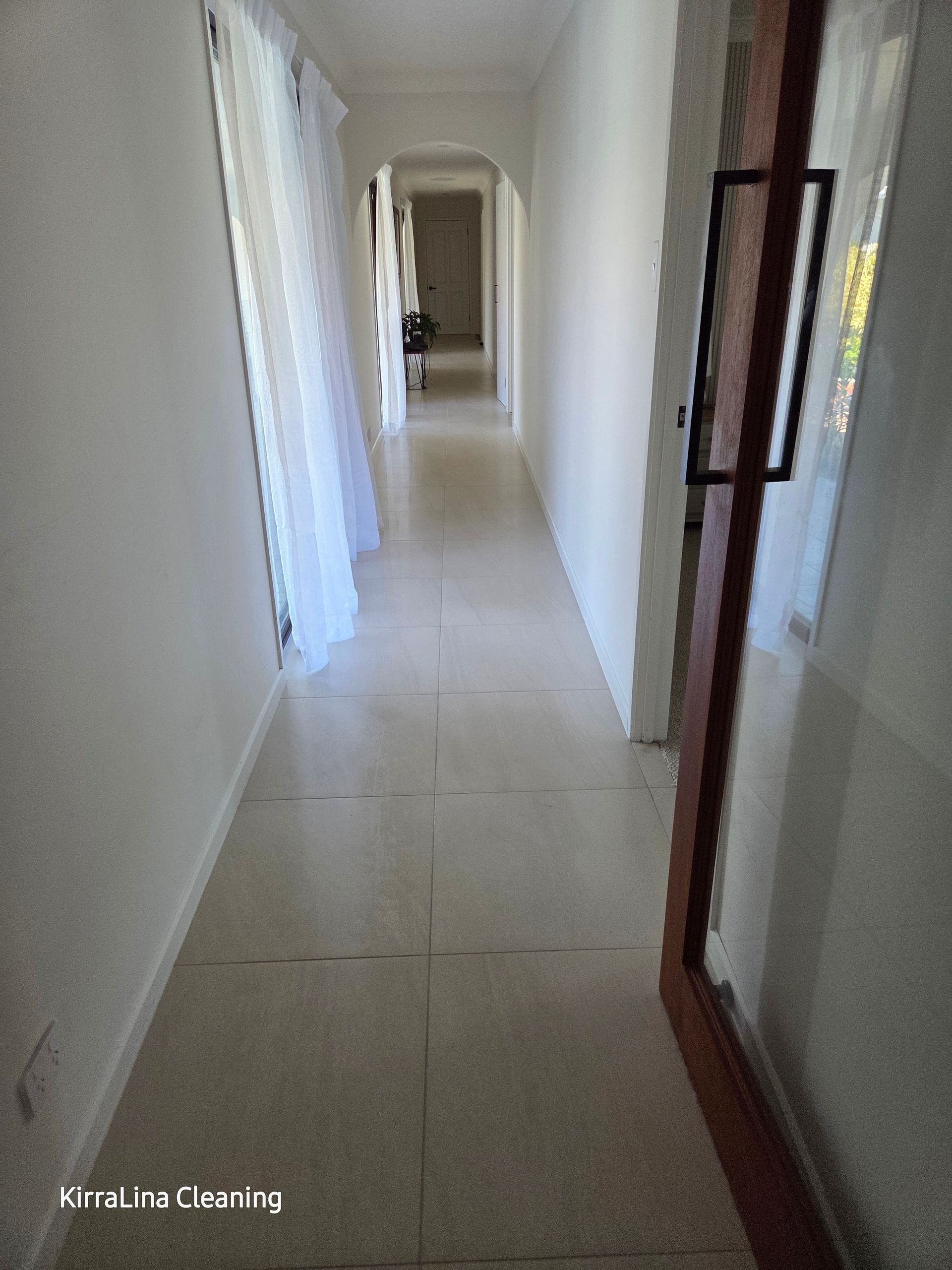 Long, narrow hallway with off-white walls, tiled floor, and a doorway on the right. Sheer curtains are on the left — KirraLina Cleaning Services in Tweed Heads, NSW