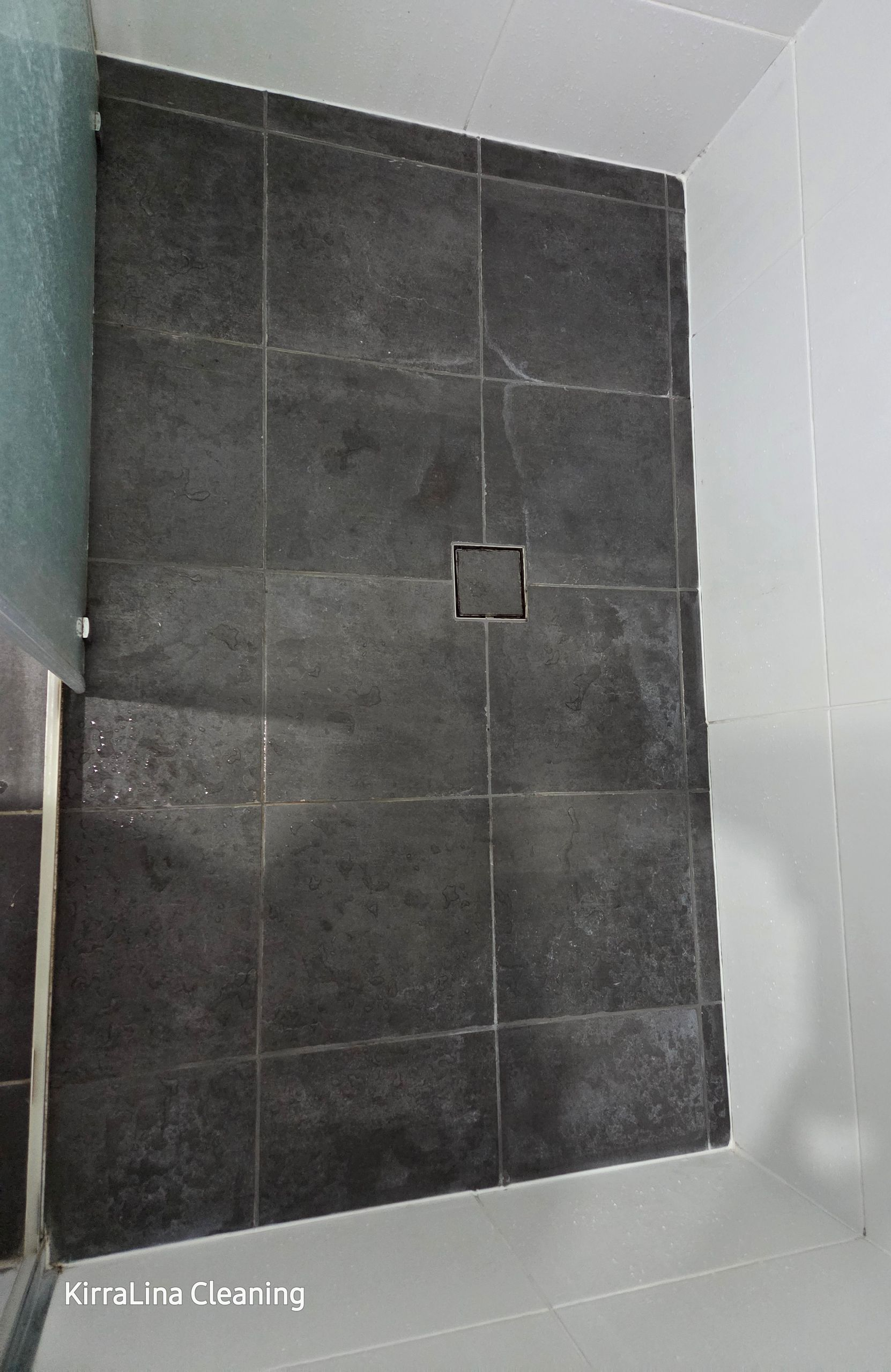 Dark Gray Tiled Shower Floor With a Small Square Drain in the Center — KirraLina Cleaning Services in Tweed Heads, NSW