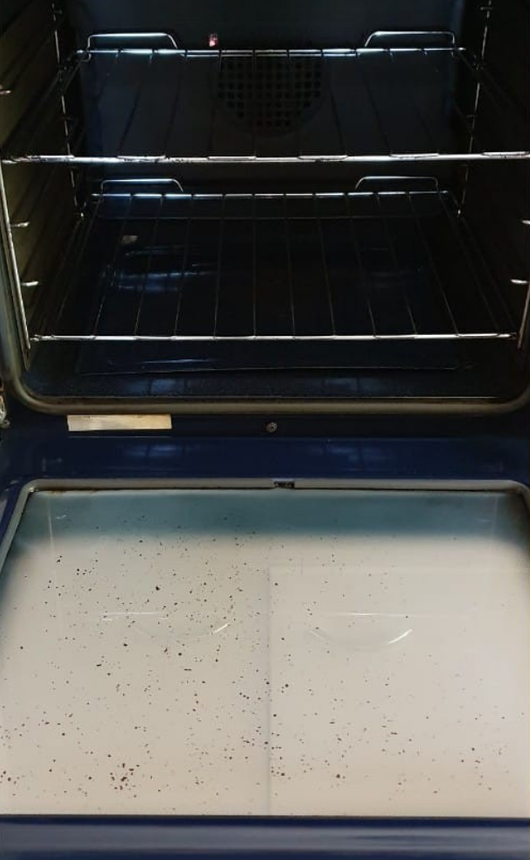 Open Oven Interior with Dark Racks, a Wire Shelf, and A Dirty Glass Door — KirraLina Cleaning Services in Tweed Heads, NSW