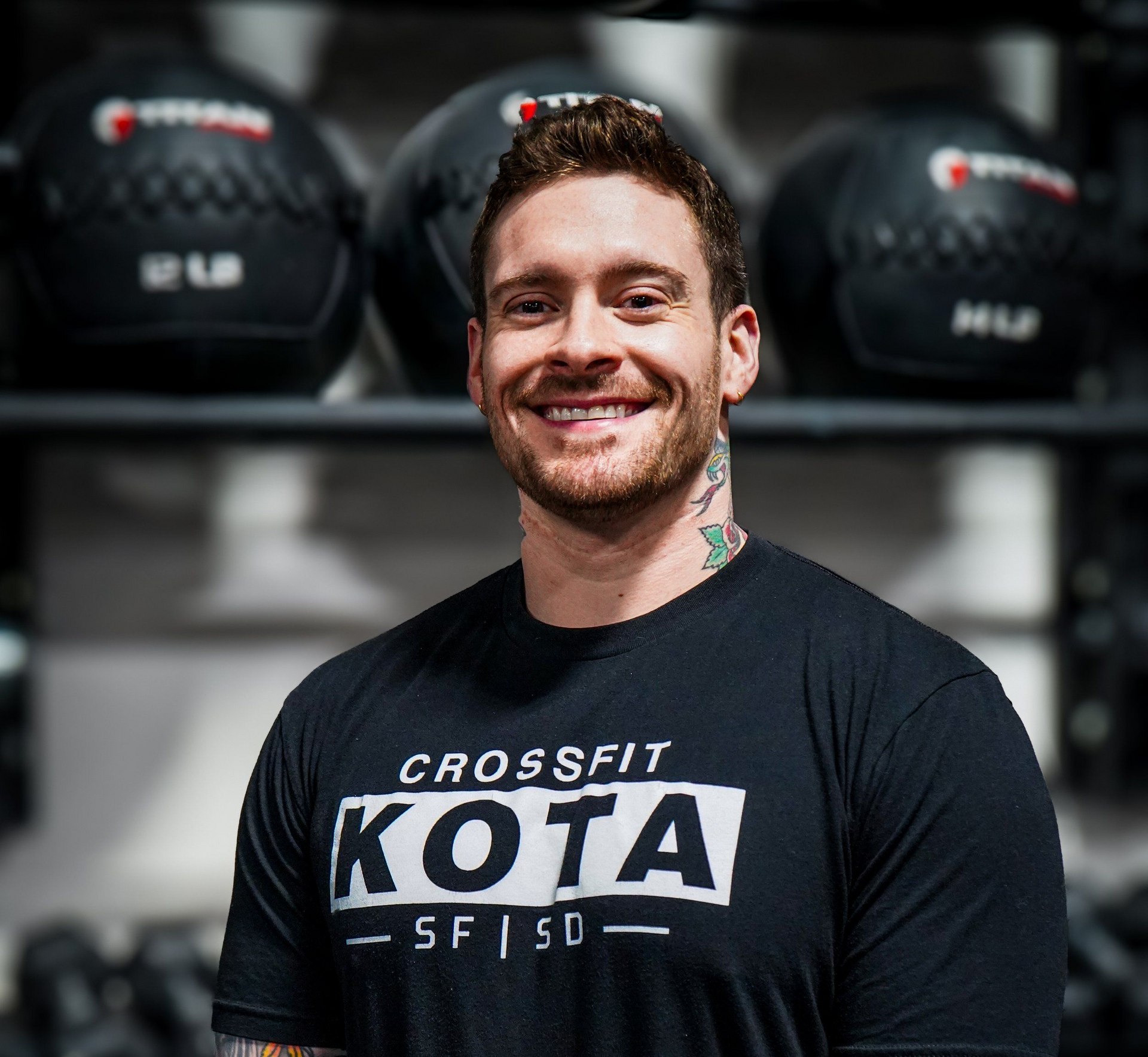 Smiling man with tattoos wearing a black