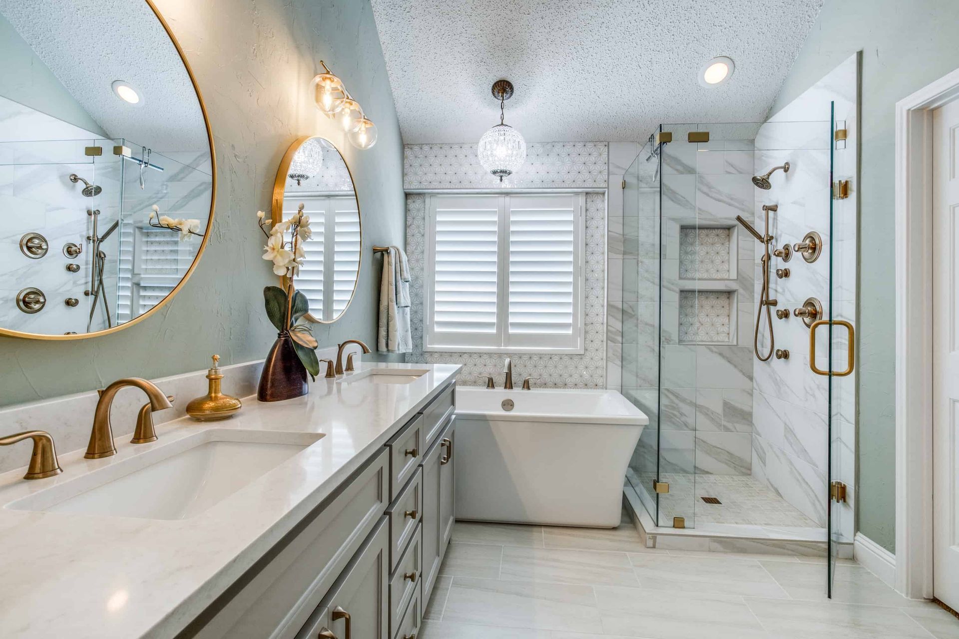 Luxurious bathroom with double sink vanity, large mirrors, soaking tub, and marble shower.