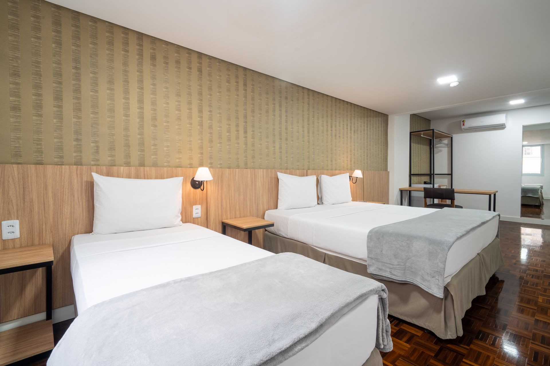 quarto standard com 1 cama de solteiro e uma de casal, mesa de trabalho, frigobar