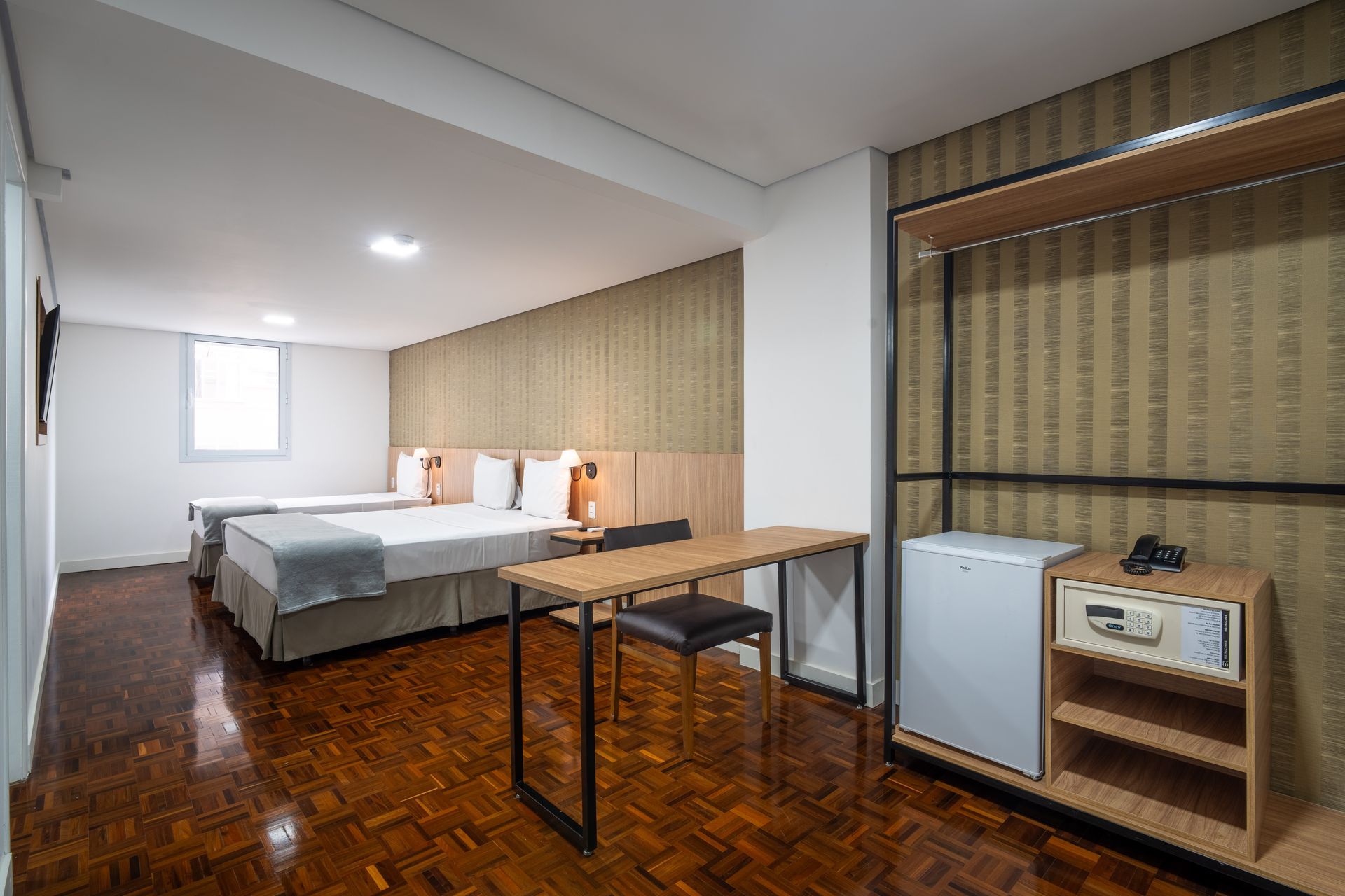 quarto standard com 1 cama de solteiro e uma de casal, mesa de trabalho, frigobar