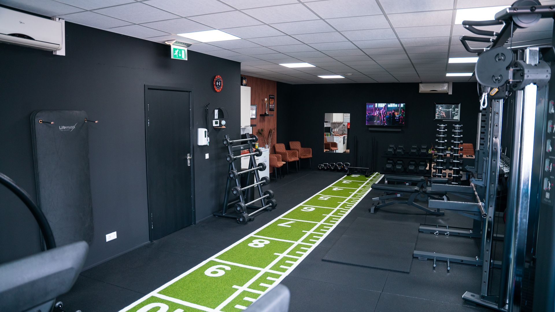 Een man zit op een hometrainer in een sportschool.