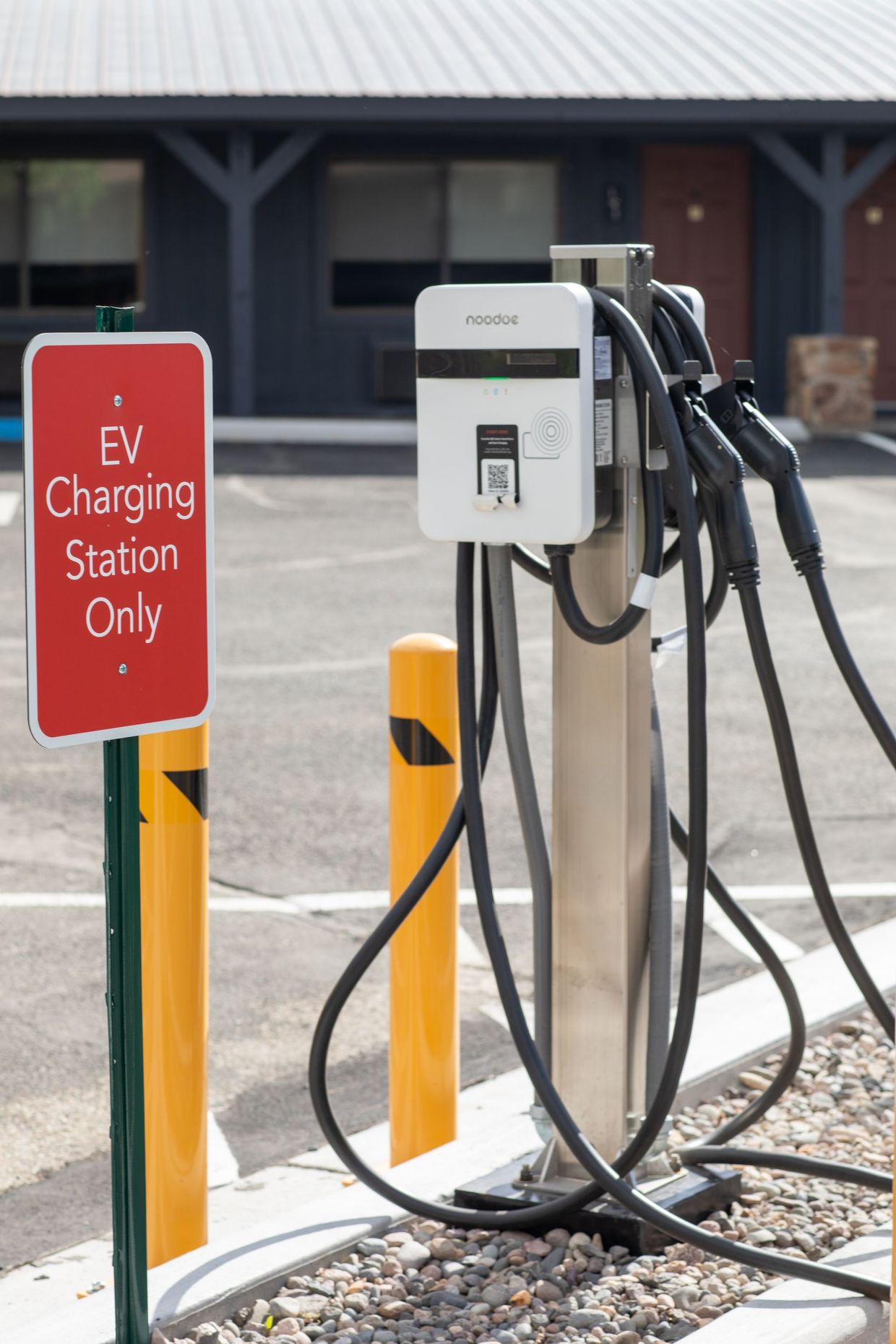EV charging station with multiple cables beside a red “EV Charging Station Only” sign