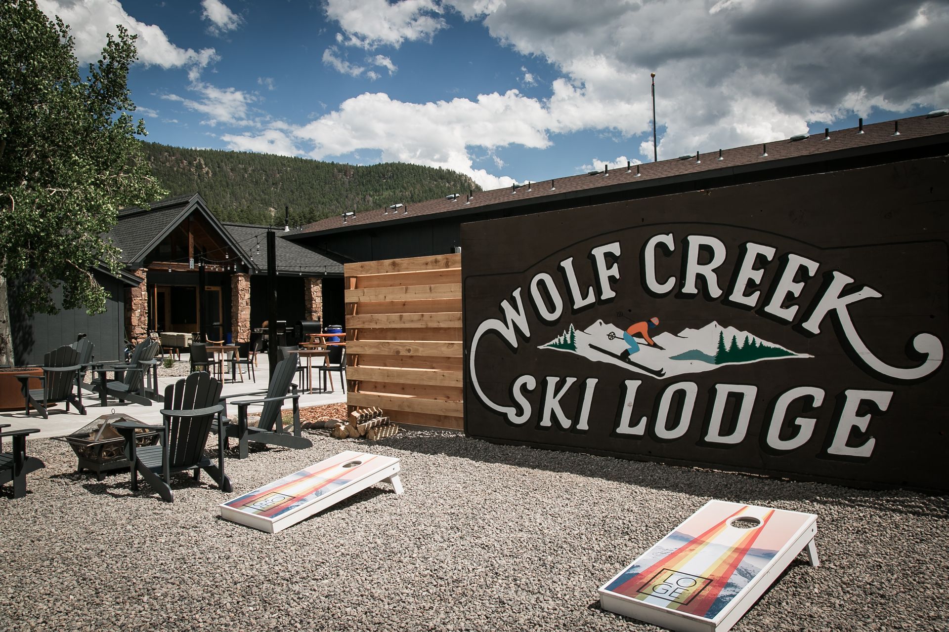 Wolf Creek Ski Lodge sign outside a rustic mountain lodge with patio tables and chairs