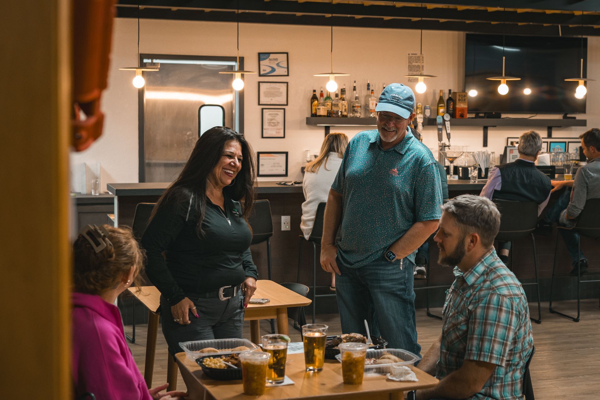 People chatting around a table in a cozy café with drinks and warm lighting