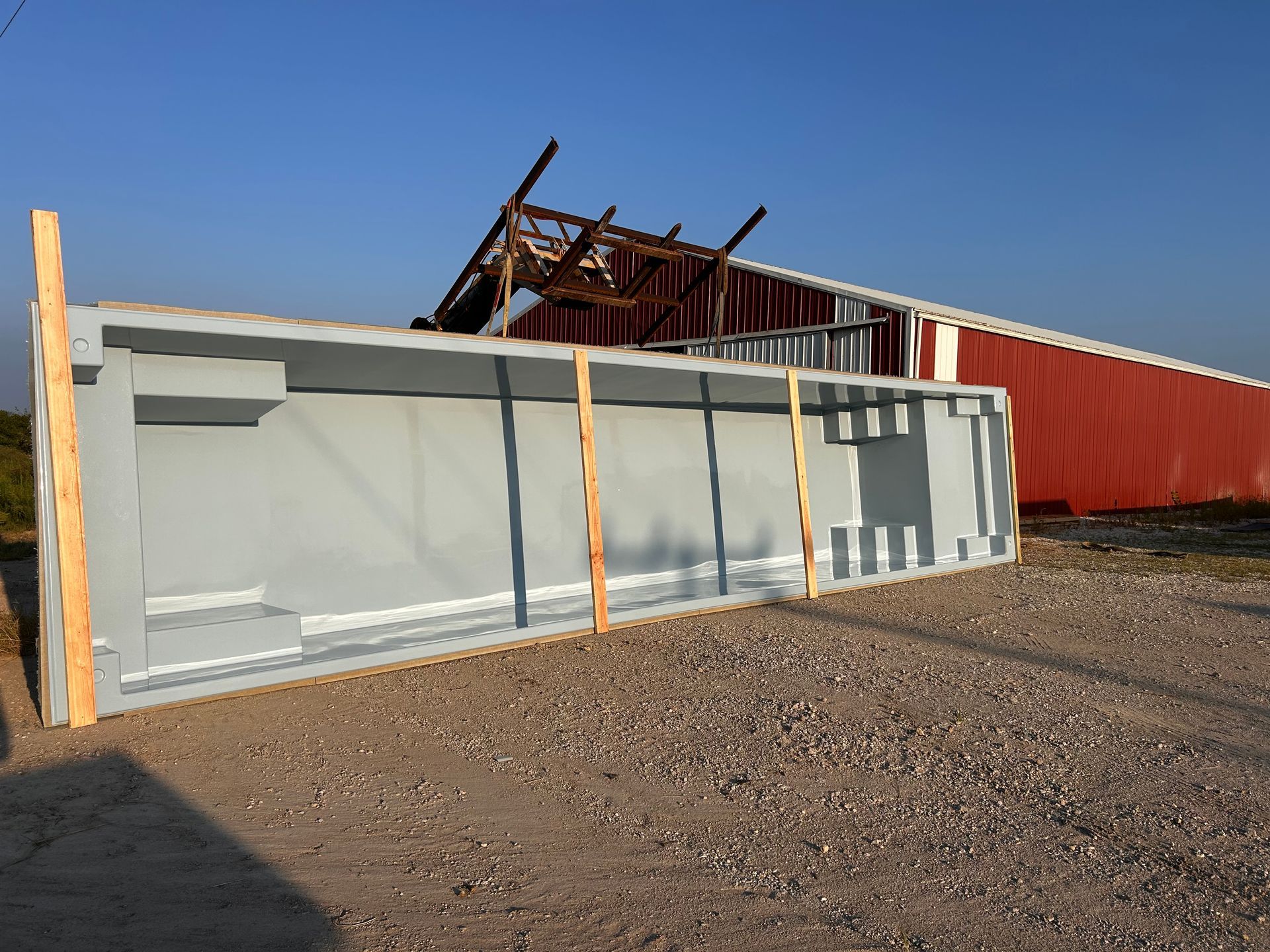 A large gray container is sitting on the ground in front of a building.