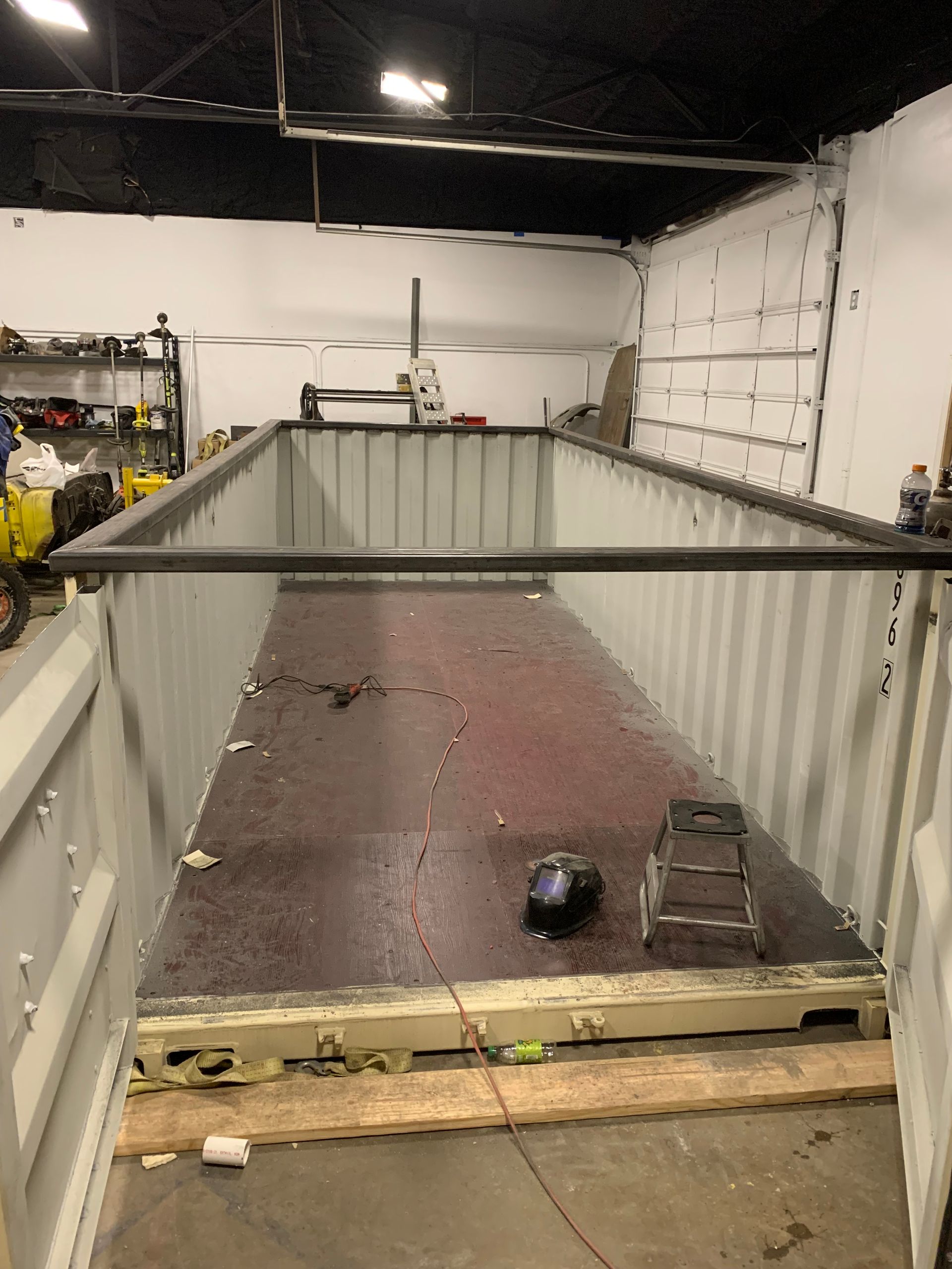 A large shipping container is sitting in a garage.