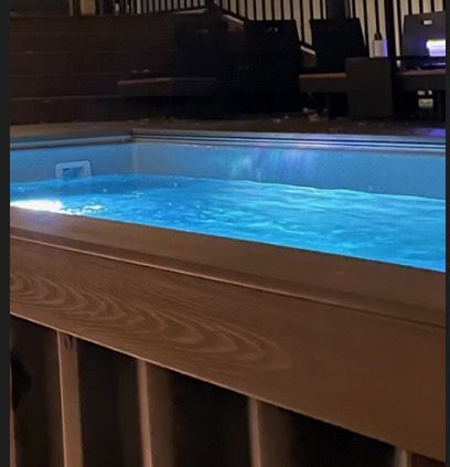 A swimming pool with blue water and a wooden railing