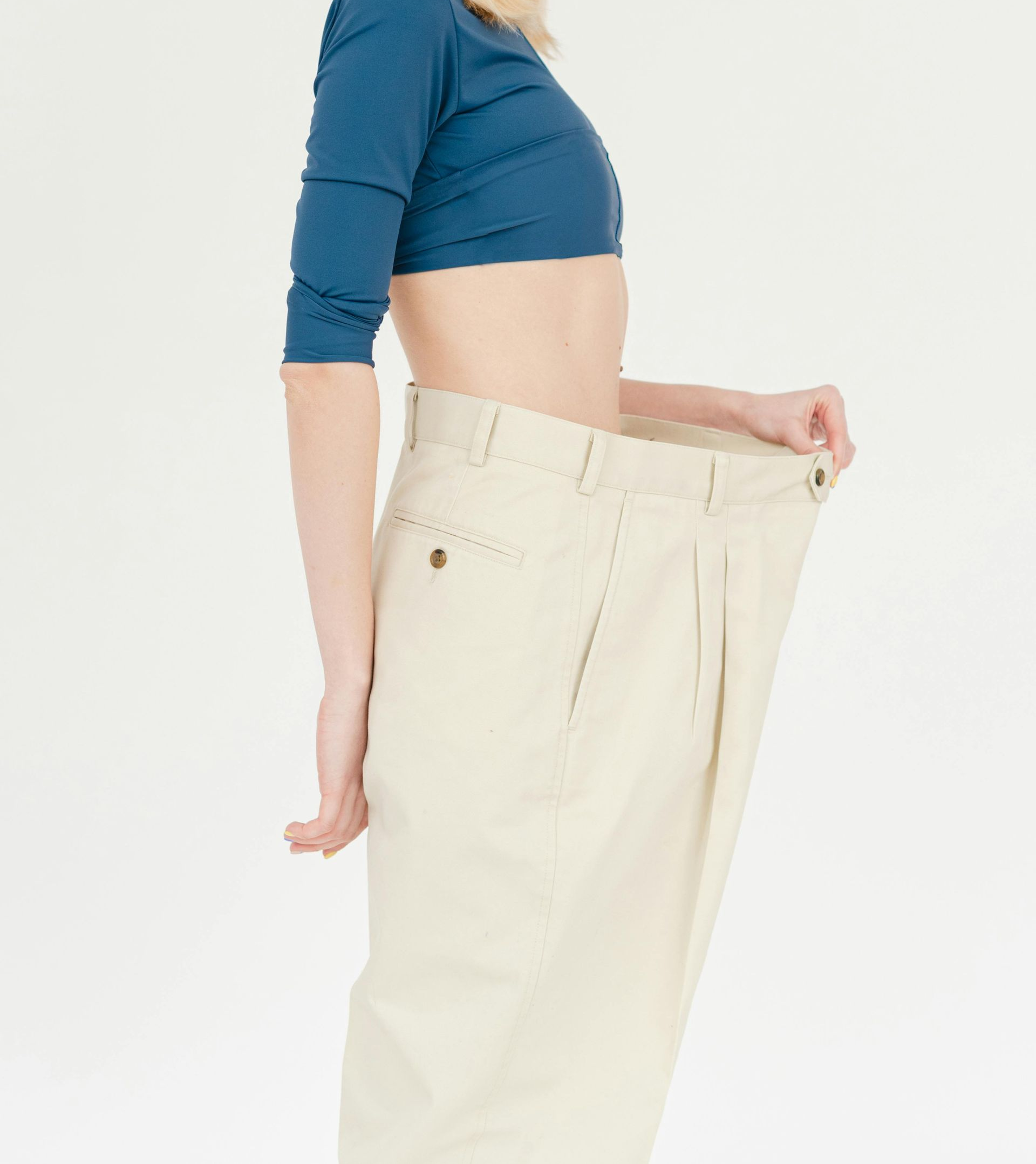 Woman wearing oversized pants, demonstrating weight loss.