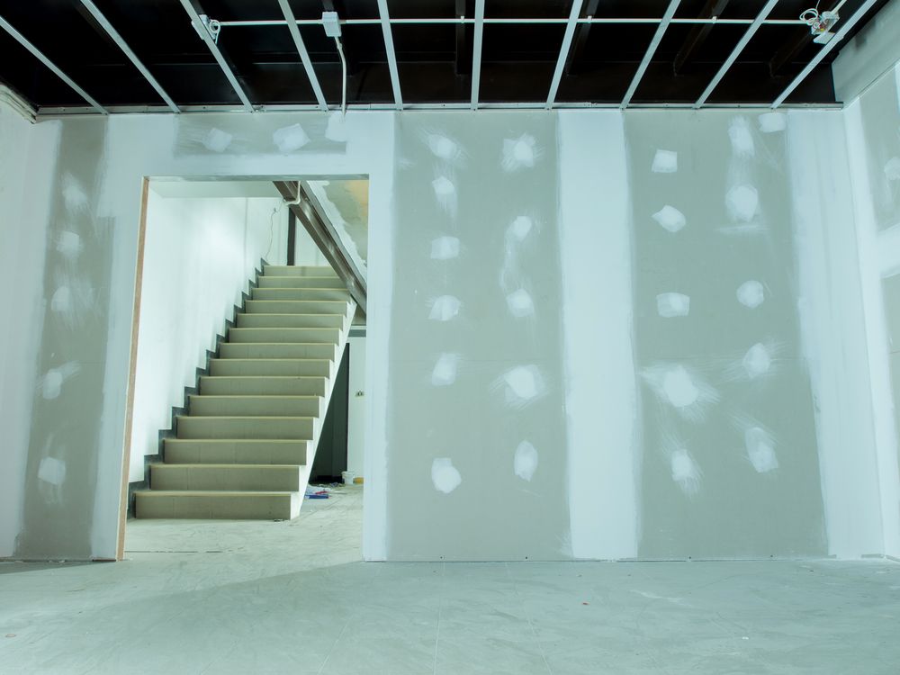 An Empty Room With a Staircase Leading to the Second Floor — Clean Line Plastering in Forster - Tuncurry, NSW