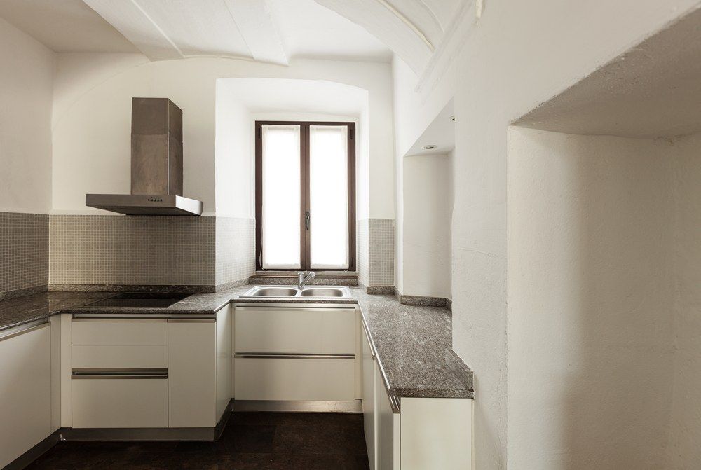 A Kitchen With White Cabinets and Stainless Steel Appliances — Clean Line Plastering in Forster - Tuncurry, NSW