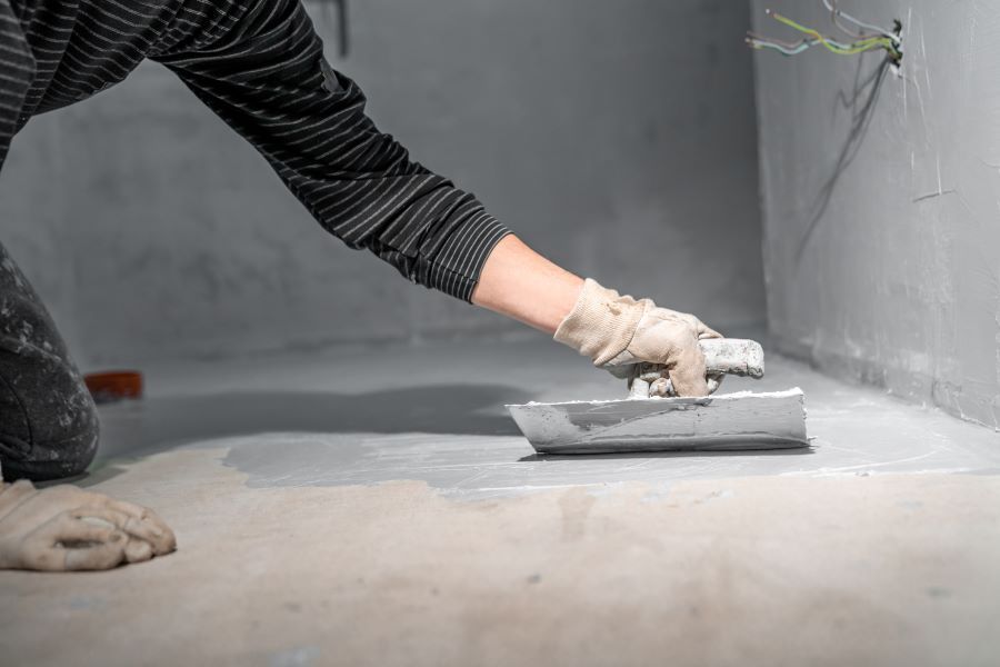 A Person is Using a Trowel to Plaster a Floor — Clean Line Plastering in Old Bar, NSW