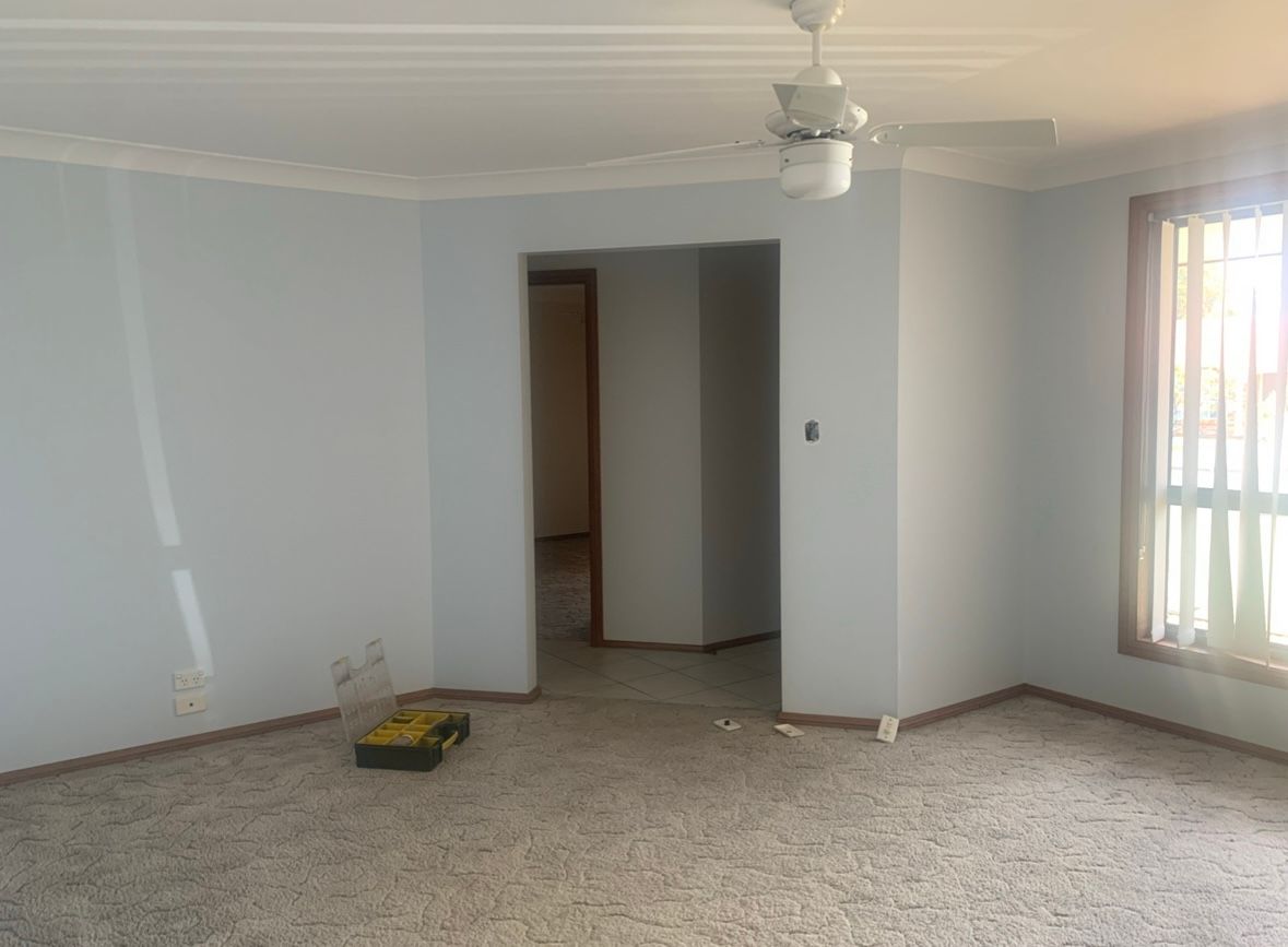 A Person is Plastering a Wall With a Angle Float — Clean Line Plastering in Forster, NSW