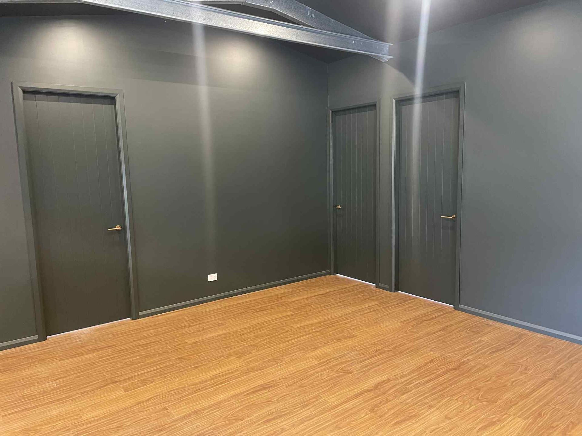A Man is Standing on a Ladder Plastering the Ceiling of a Room — Clean Line Plastering in Forster - Tuncurry, NSW
