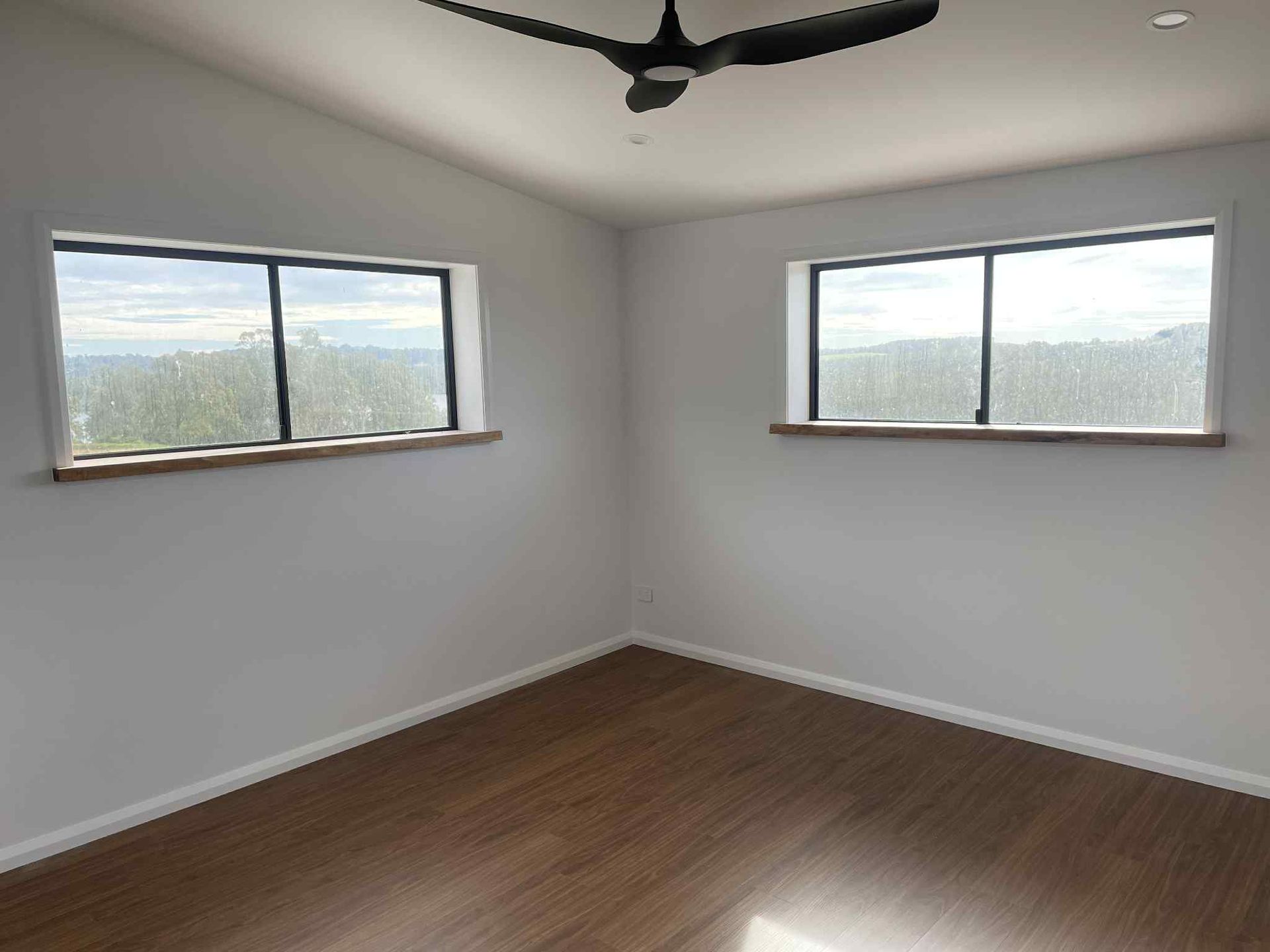 A Man is Using a Drill to Drill a Hole in a Wall — Clean Line Plastering in Forster - Tuncurry, NSW