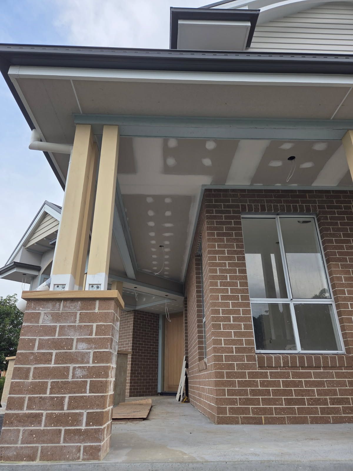 A Person is Using a Trowel to Plaster a Wall — Clean Line Plastering in Forster - Tuncurry, NSW