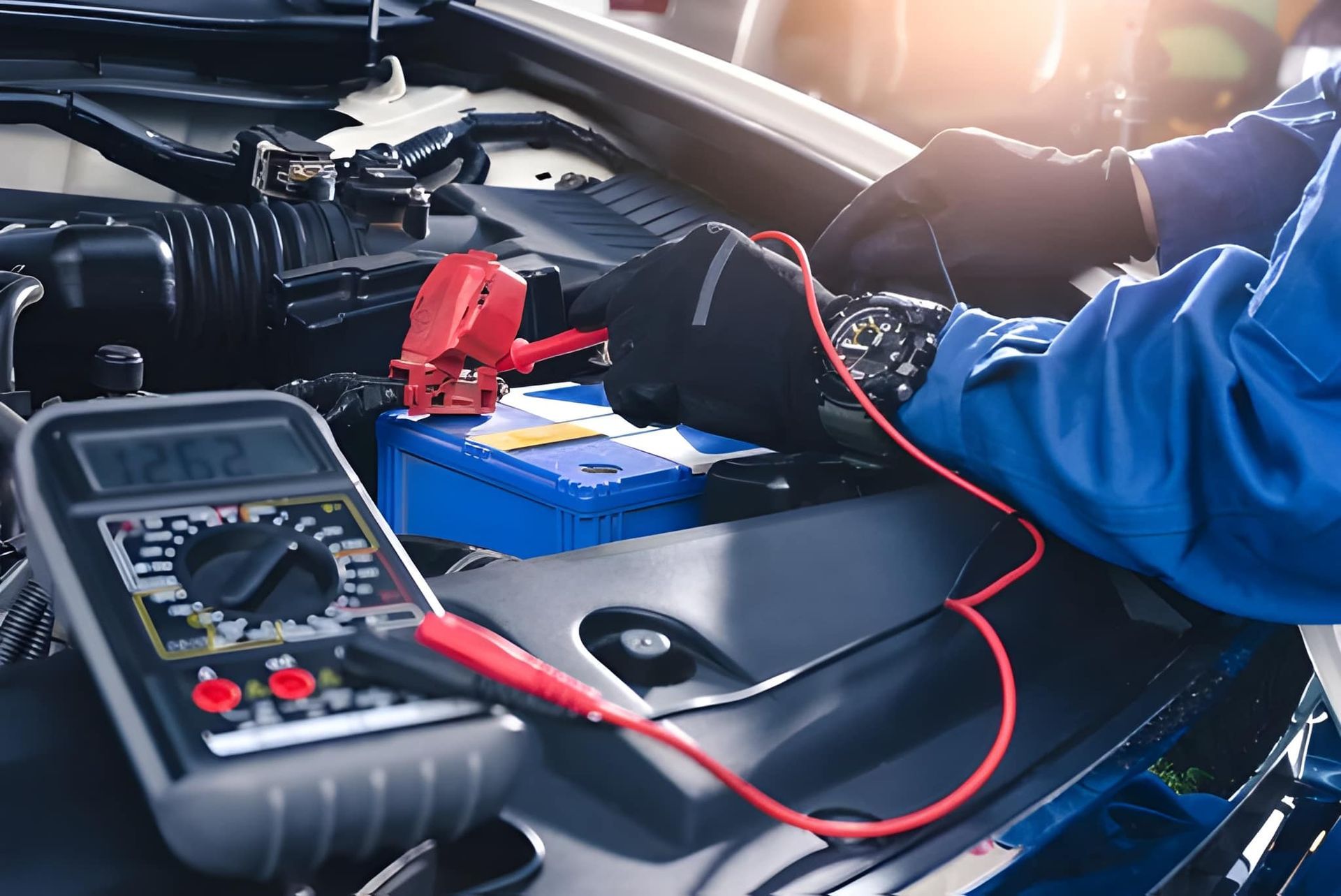 Mechanic Testing a Car Battery With a Multimeter Under the Hood — Mechanical Care in Belconnen, ACT
