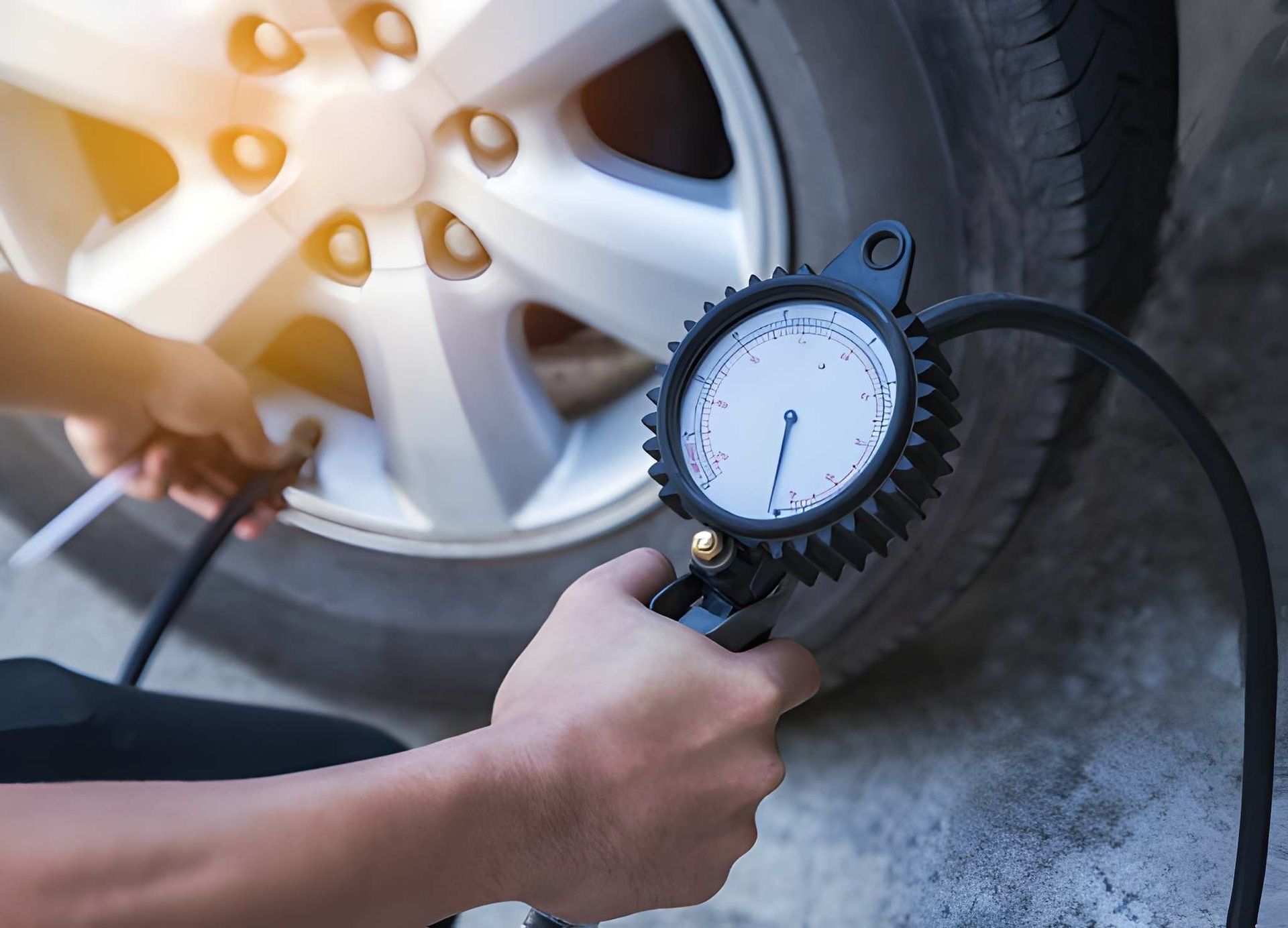 Person Checking Tire Pressure With a Gauge Near a Car Wheel — Mechanical Care in Belconnen, ACT