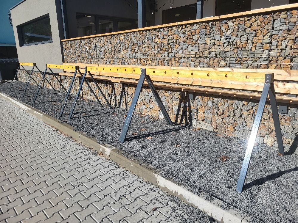 Un chantier de construction avec des échafaudages soutenant un coffrage en bois contre un mur en pierre.