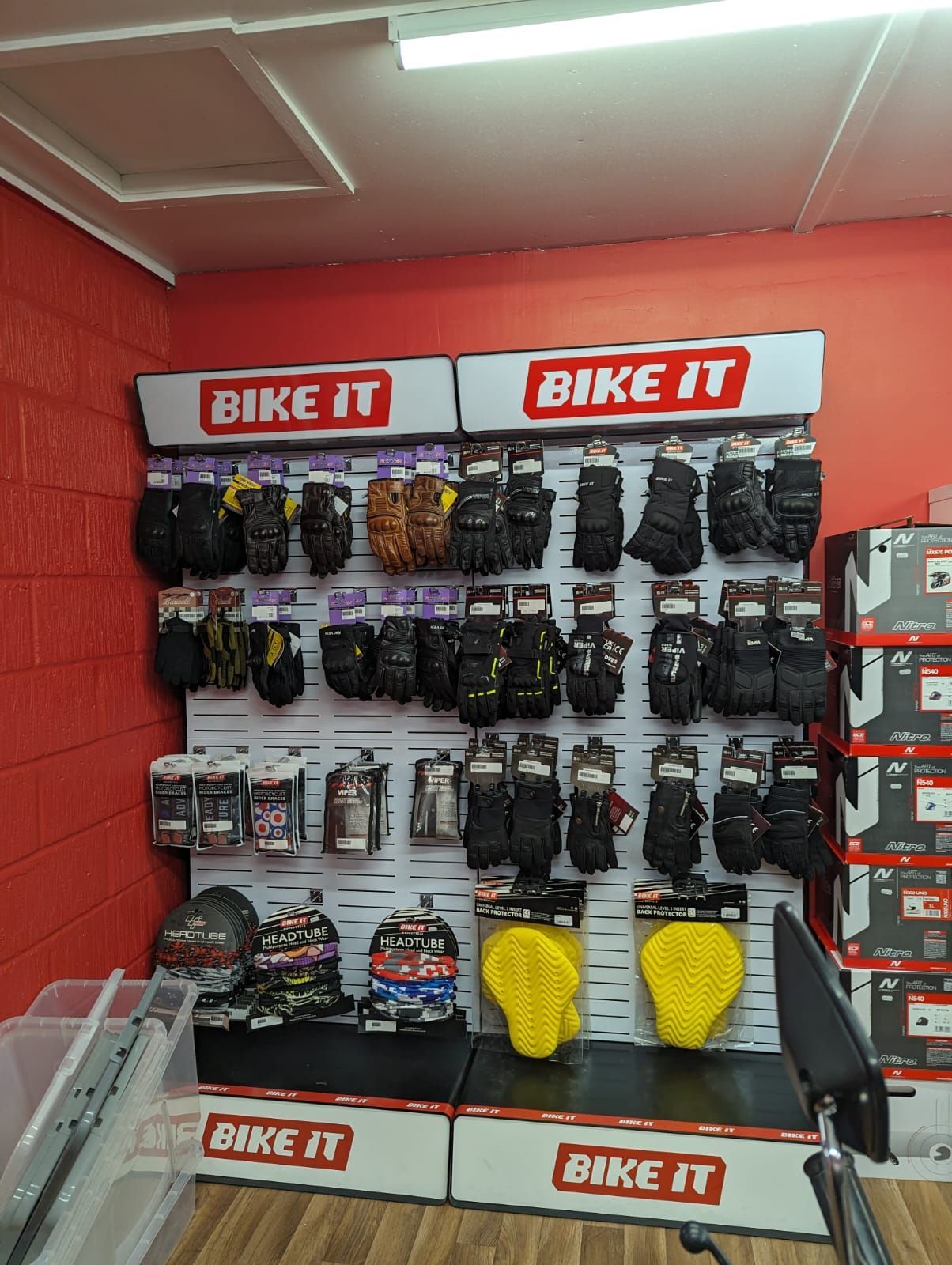 A store display featuring motorcycle gloves and gear. The