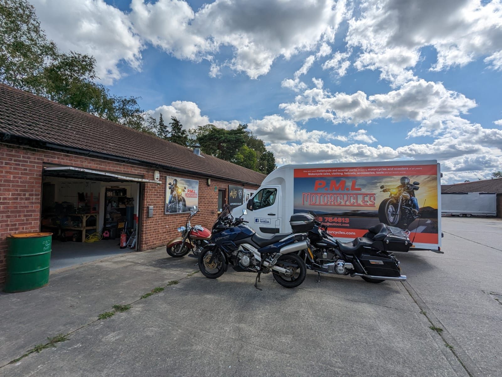 Motorcycle shop exterior with motorcycles parked out front and a branded van.