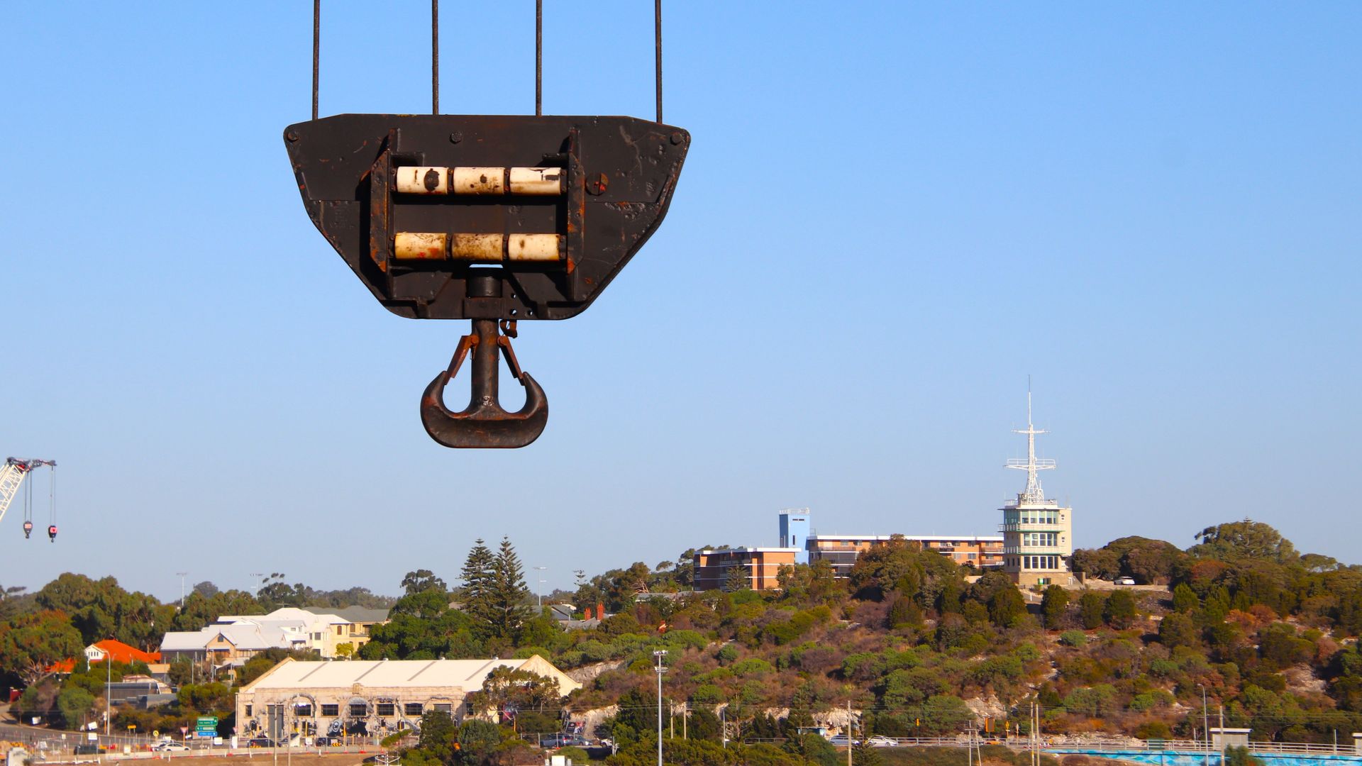 Cable car gondola suspended over a scenic hillside town under a clear blue sky