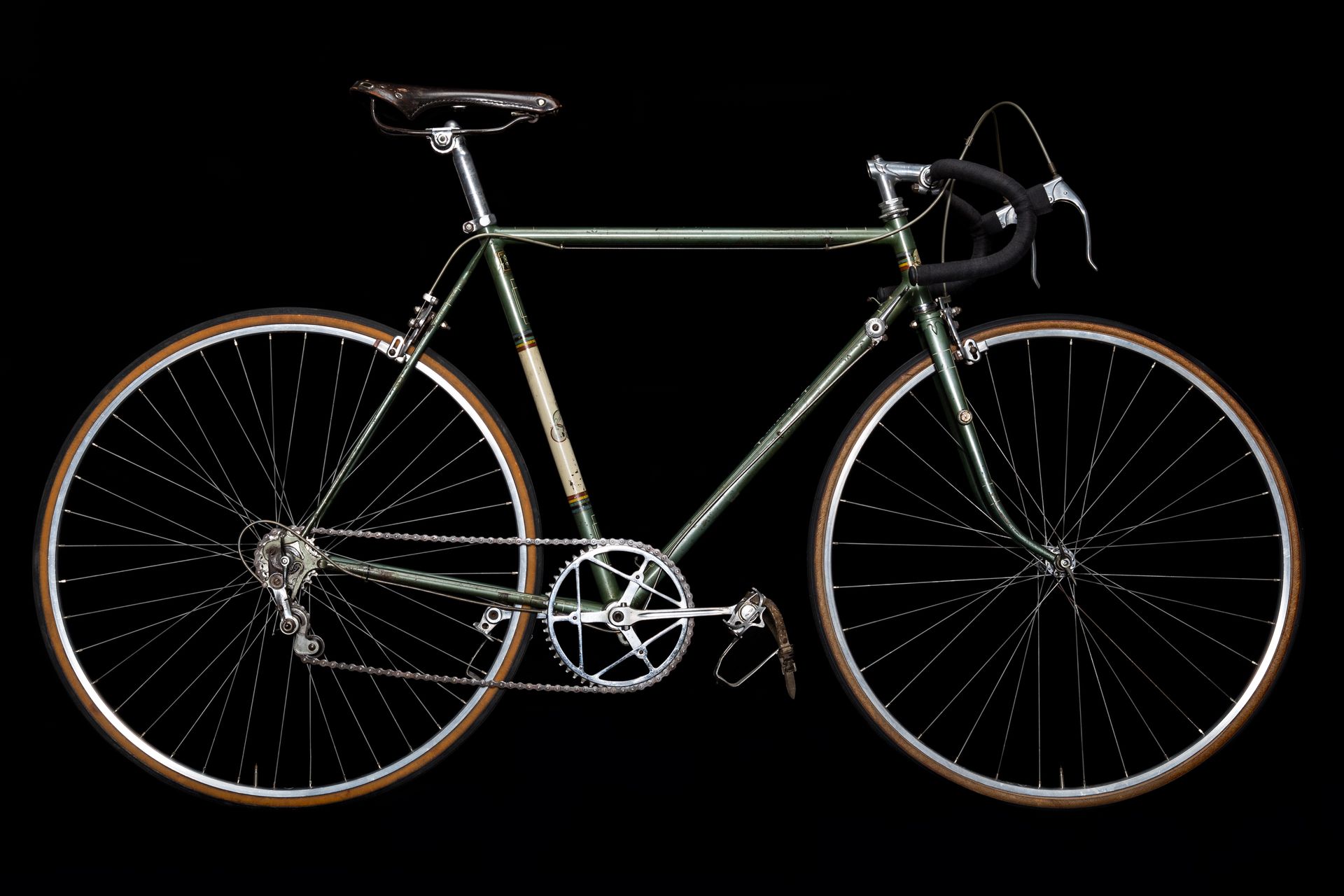 Green vintage road bicycle on a black background.