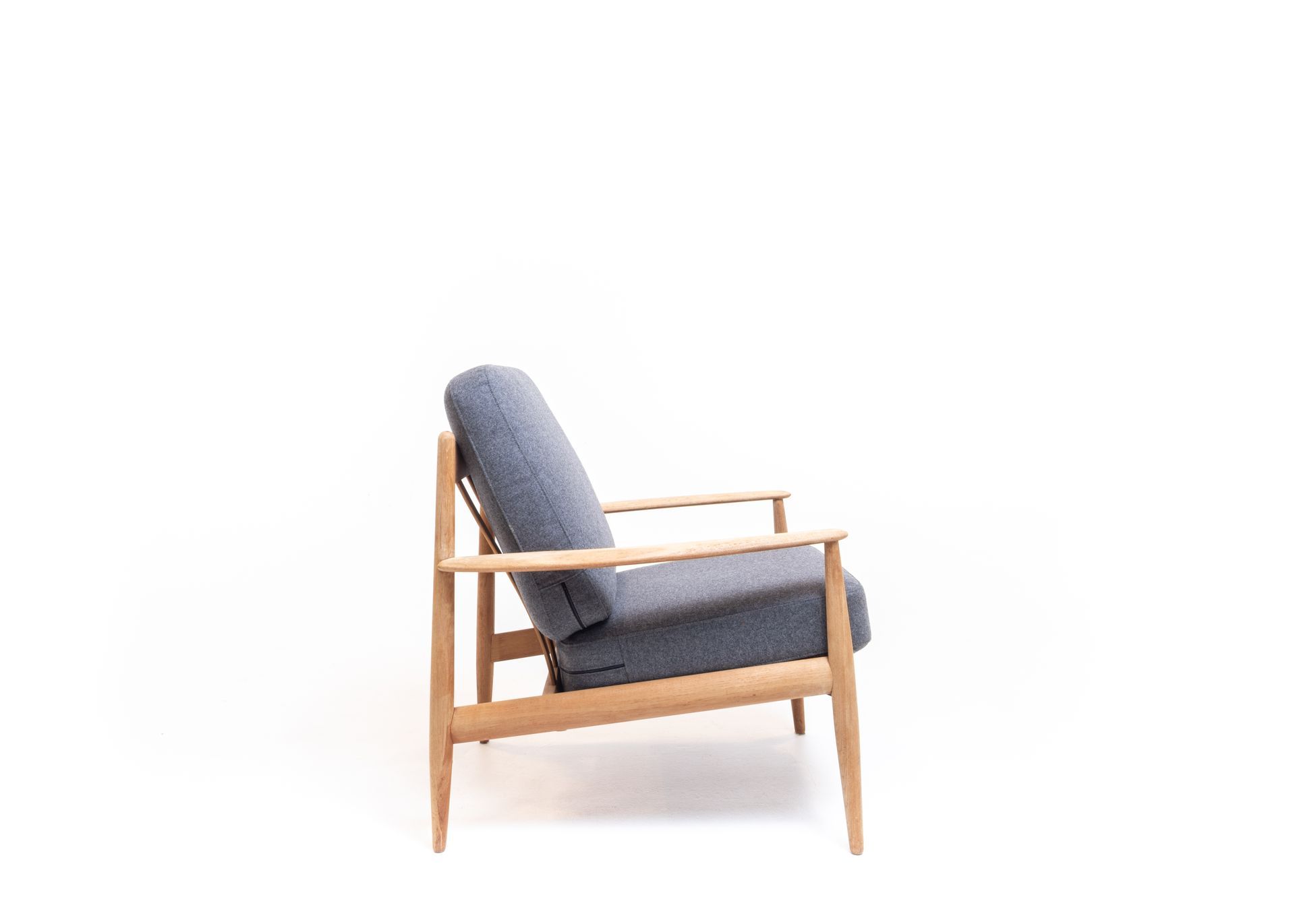 Blue upholstered armchair with light wood frame on white background.