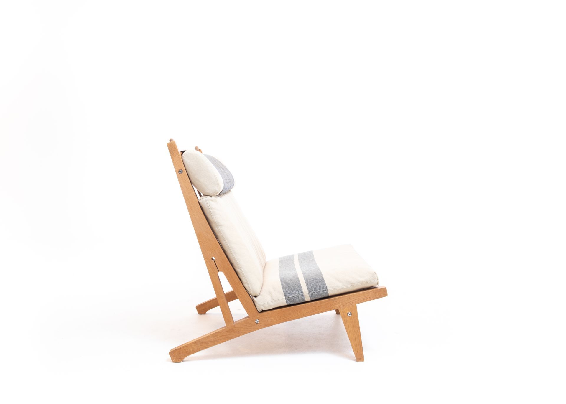 Wooden lounge chair with white cushion and blue stripes, against white background.