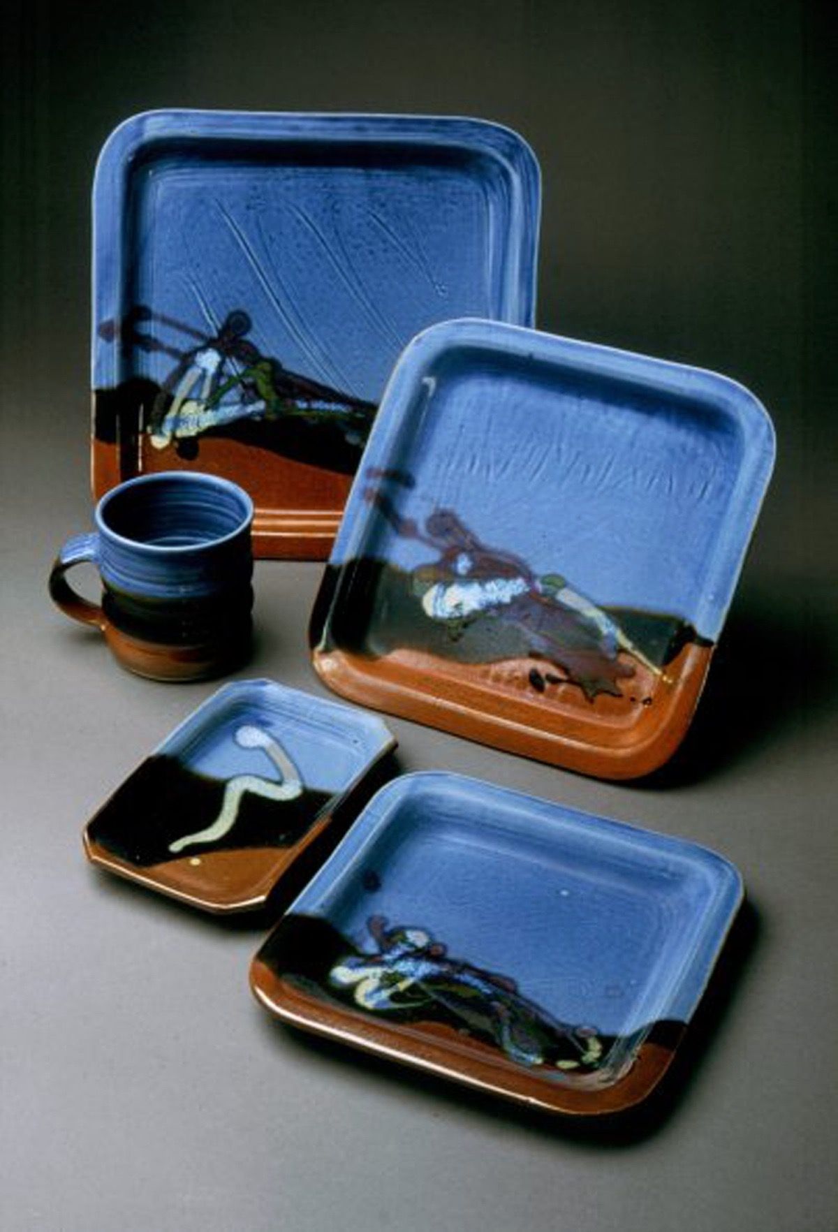 A set of blue and brown plates and a mug on a table.