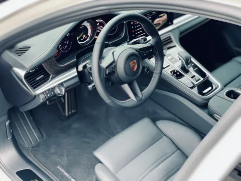 Interieur van een grijze Porsche: stuurwiel, dashboard, stoelen en middenconsole.