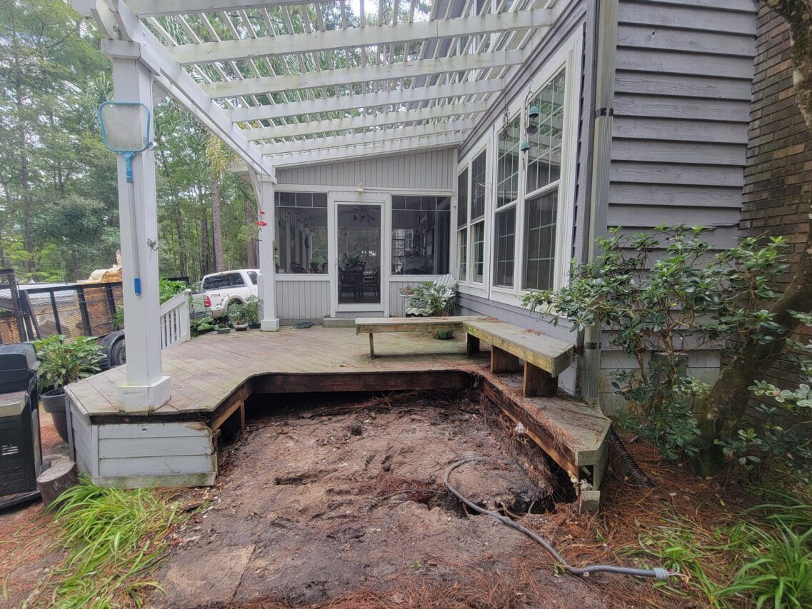 A house with a screened in porch and a wooden deck.