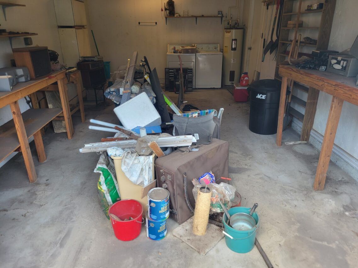 A messy garage with a bunch of trash on the floor