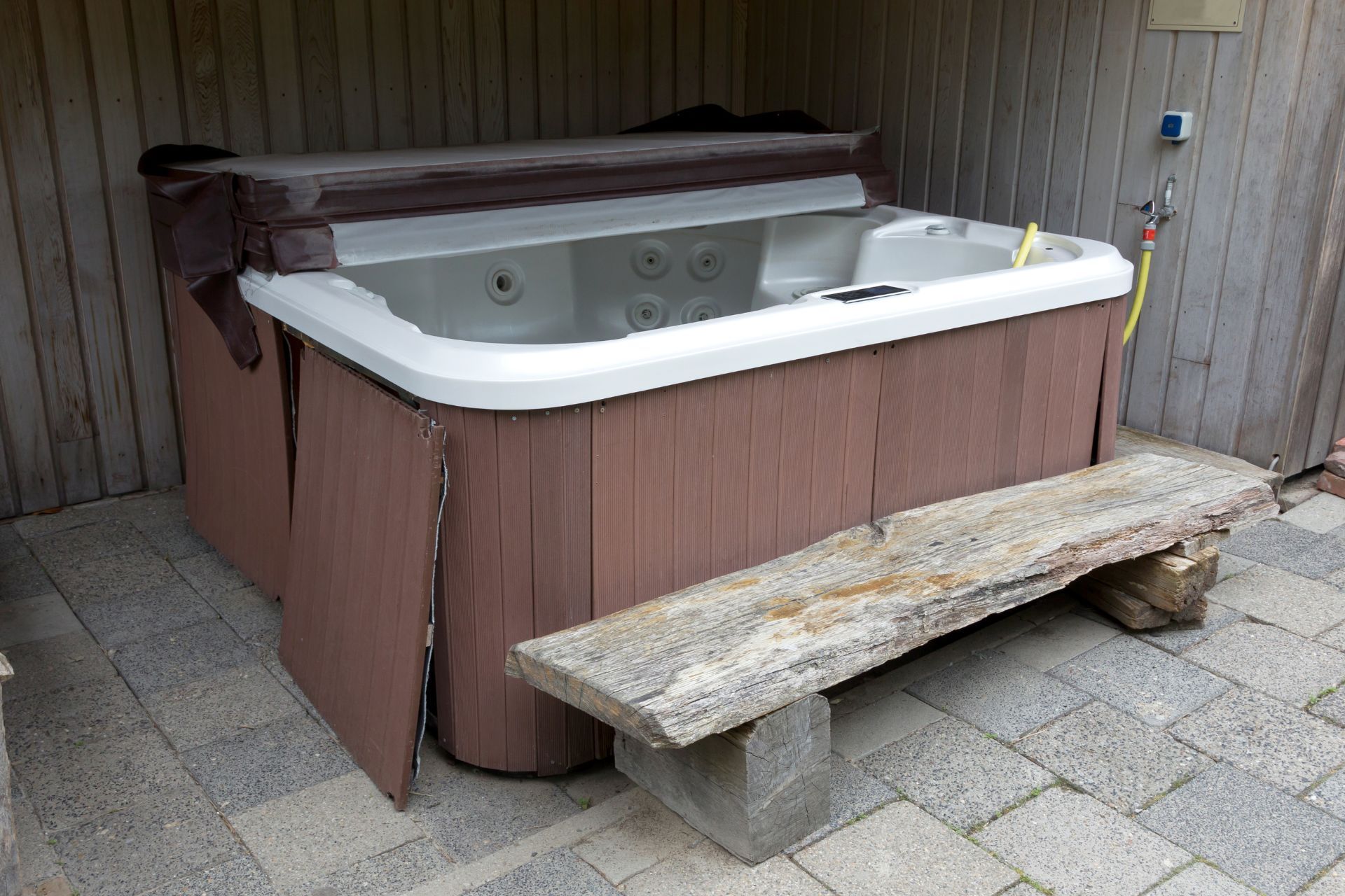 A hot tub with a wooden bench next to it