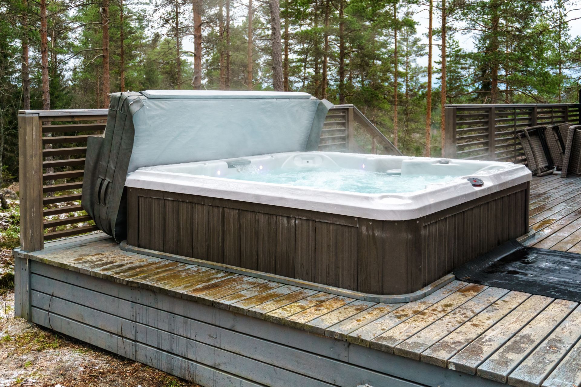 A hot tub is sitting on top of a wooden deck.
