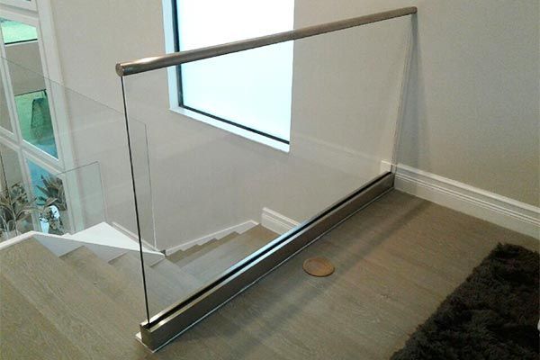 A staircase with a glass railing and a window