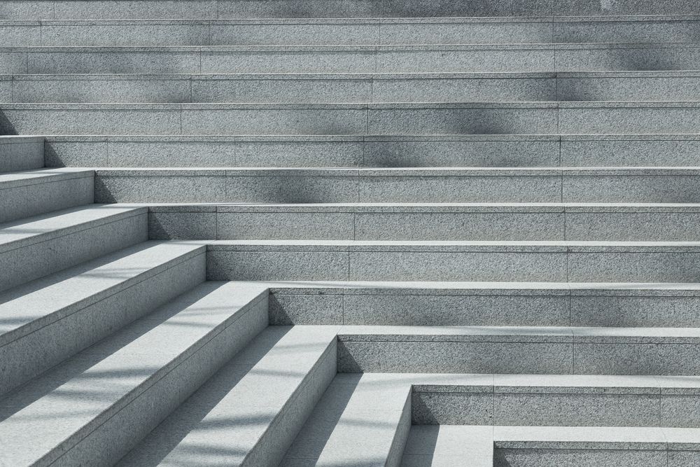 A close up of a set of stairs with shadows on them.