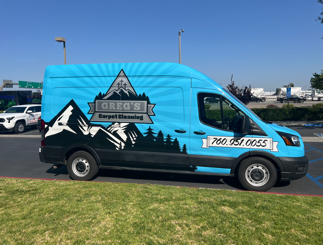 A blue van with a mountain-themed logo that says 