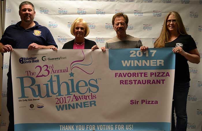 Four people holding a banner at the 23rd Annual Ruthies Awards, winner for favorite pizza restaurant, Sir Pizza
