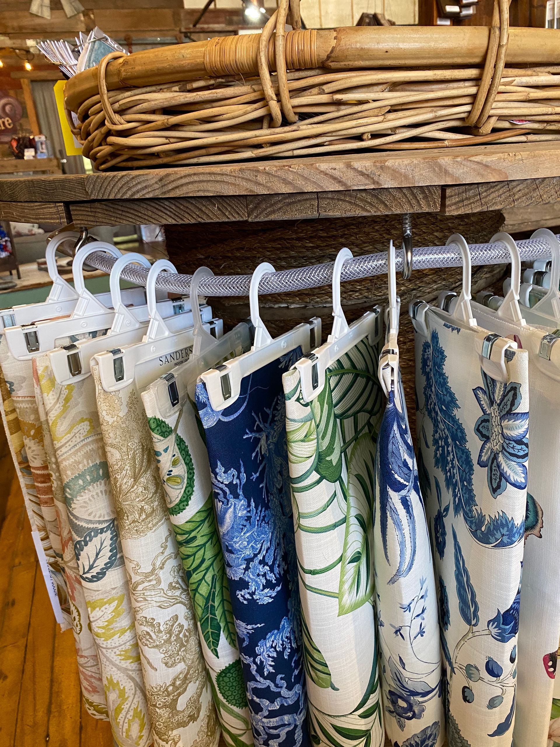 A bunch of fabric hanging on a rack in a store.