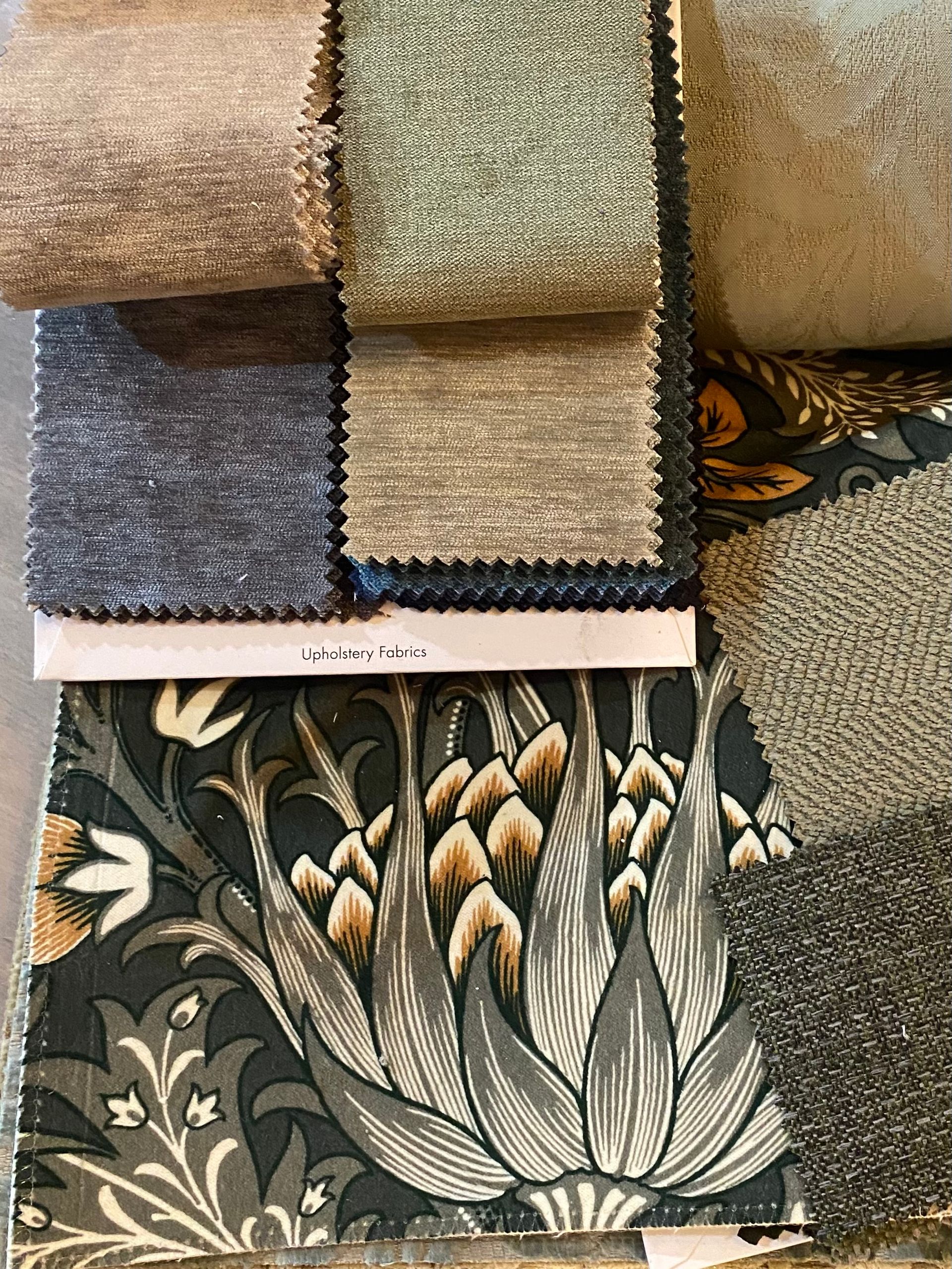 A variety of fabrics are stacked on top of each other on a table.