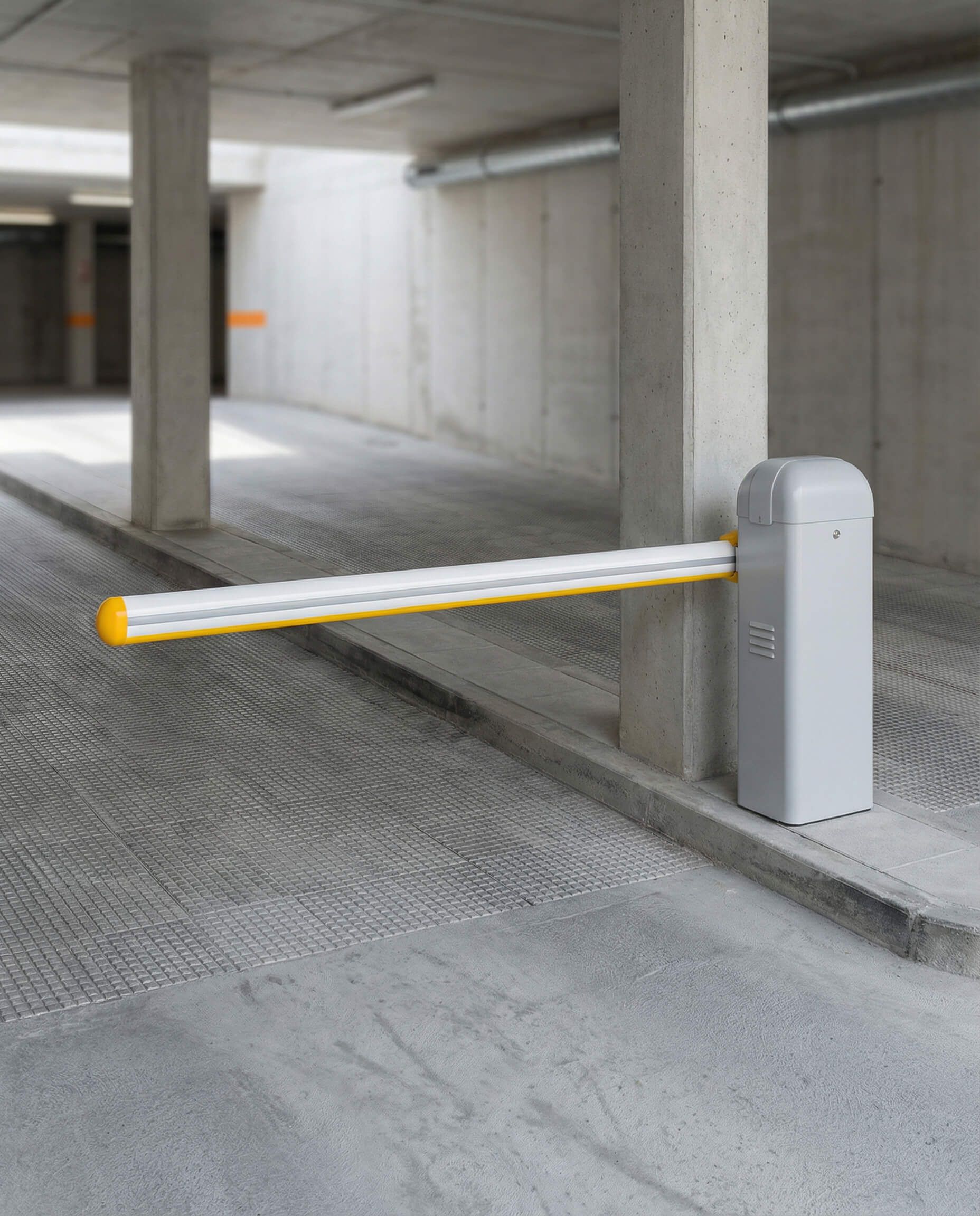 Entrada al estacionamiento con un brazo de barrera elevado de color amarillo y gris.