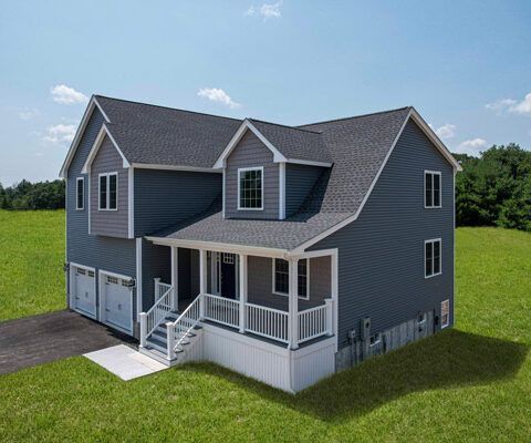 Gray two-story house with white trim, front porch, and garage on a green lawn