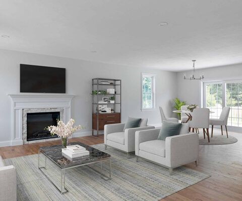Bright modern living room with white armchairs, fireplace, large TV, and dining area by windows