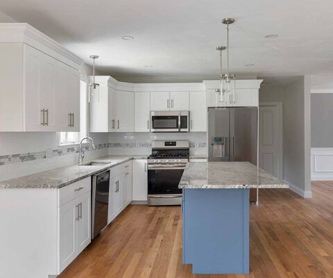 Bright white modern kitchen with stainless appliances, granite island, and wood floors