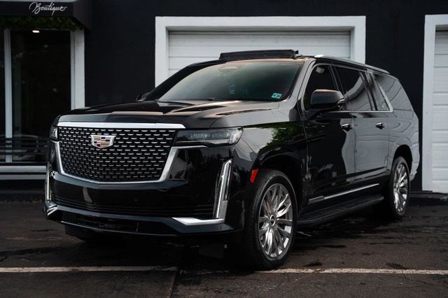 A black cadillac escalade is parked on a white background.