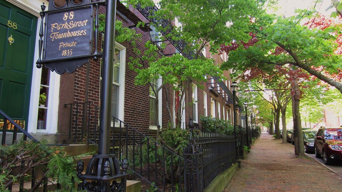 A row of houses on a street with a sign that says 25