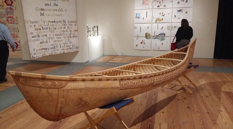 A wooden canoe is on display in a museum